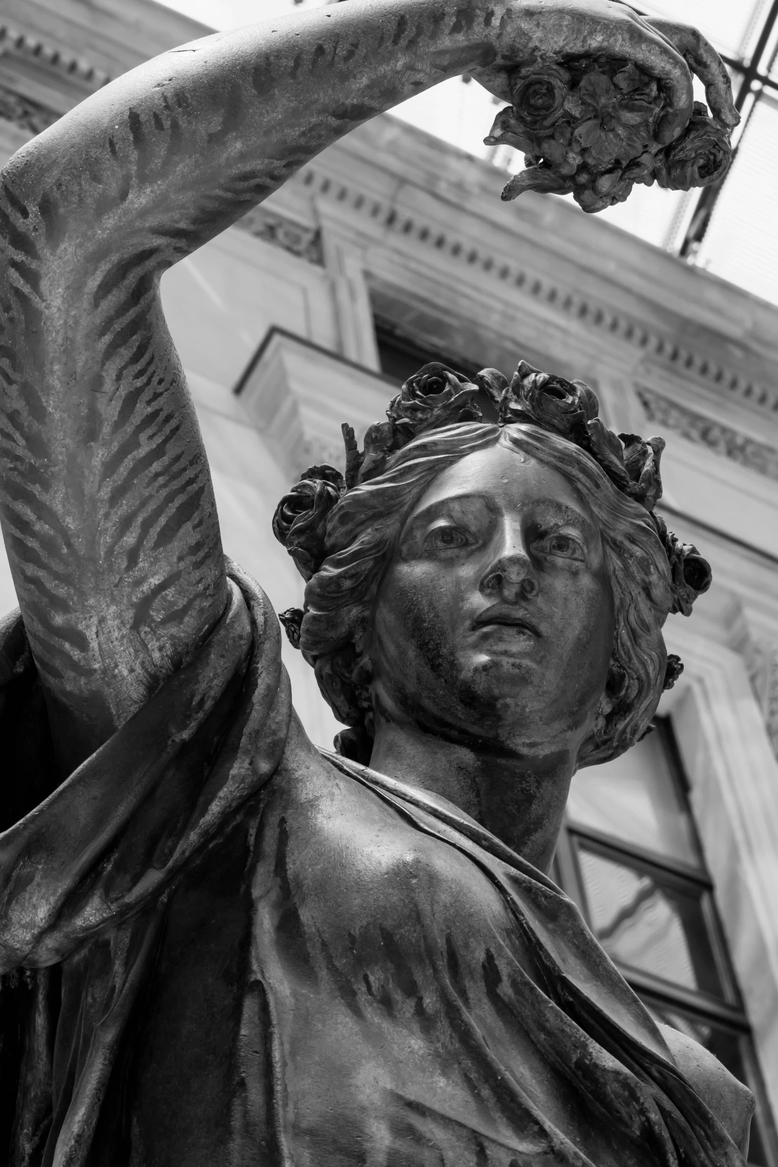 black and white pograph of a statue with a clock in the background