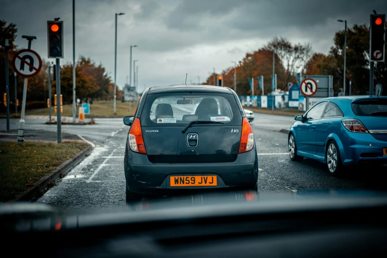 a blue car is driving down the road