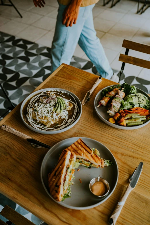 two plates of food are sitting on a table with utensils