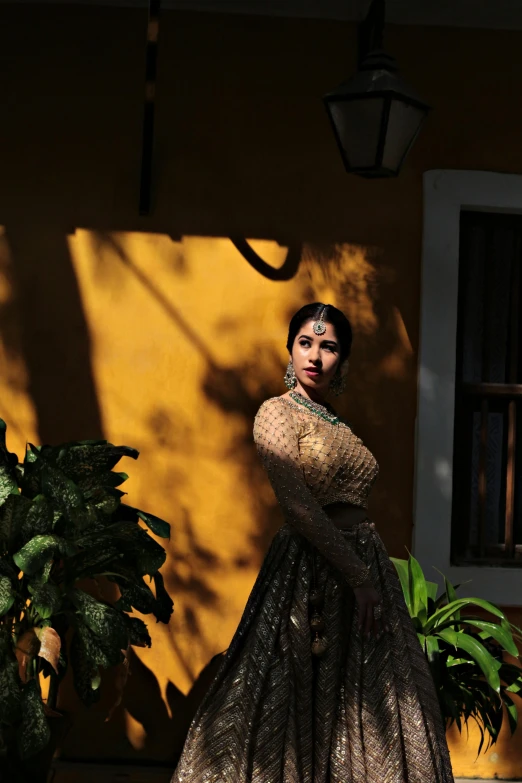 woman in long black dress standing near a wall