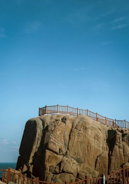 a bridge with people standing on the edge over a cliff