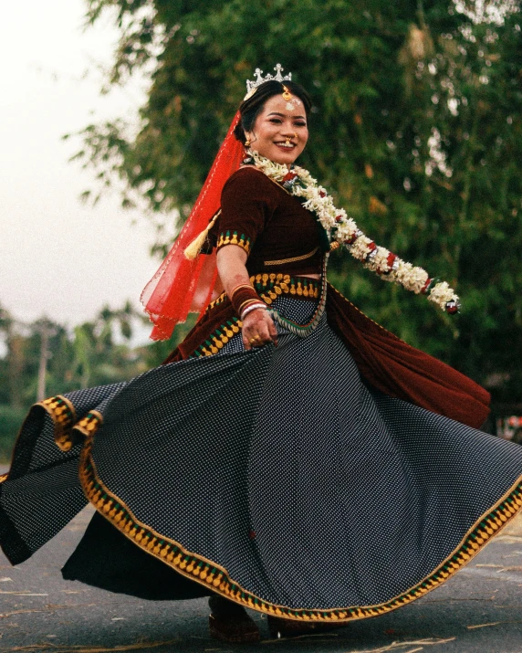 a woman wearing a red and brown outfit with an embroidered skirt