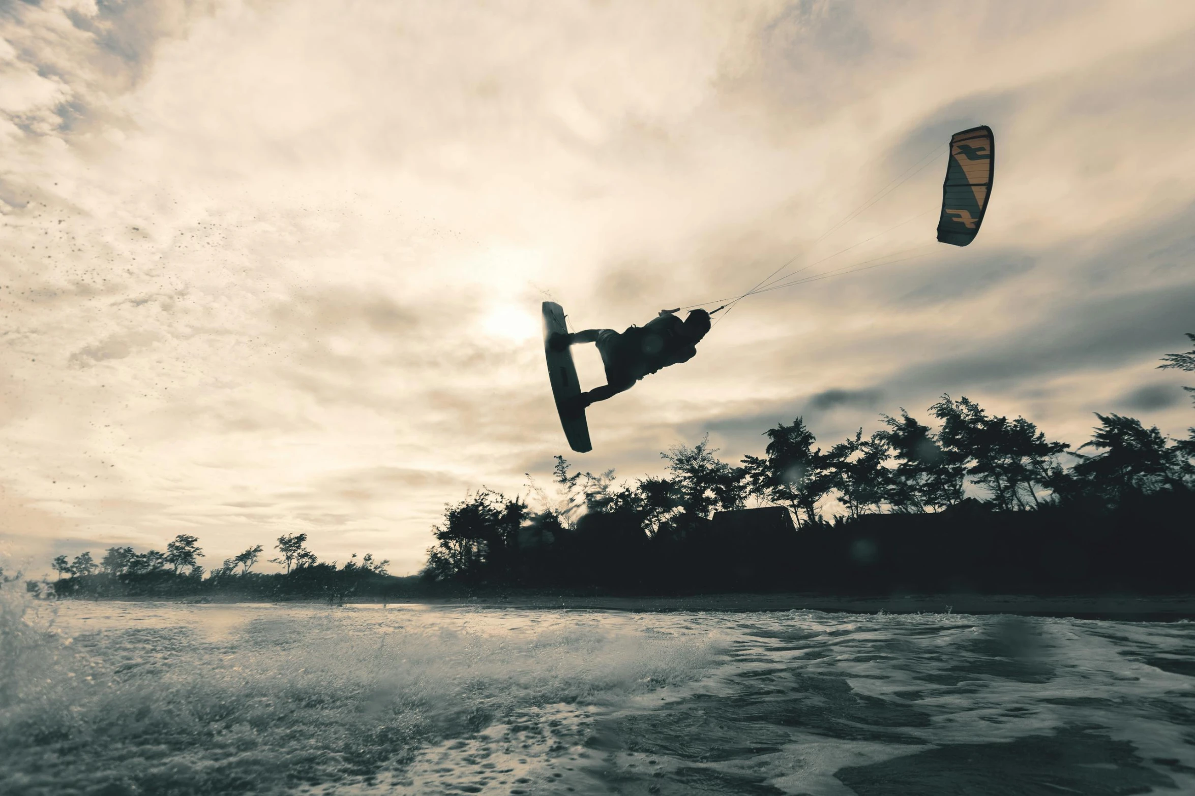 a man in black is on a surfboard with a wind sail