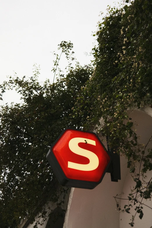 a stop sign painted red and white with a yellow letter