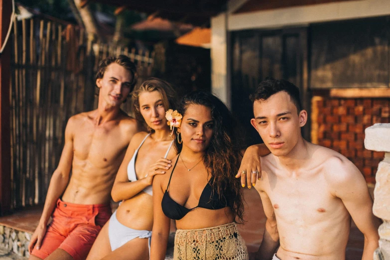 a group of shirtless people standing in front of a house