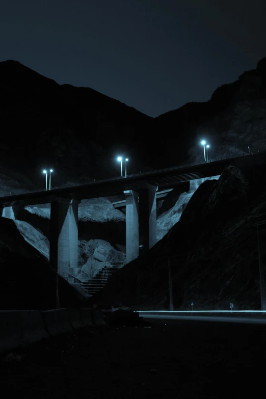 a road with lights going up to a bridge at night