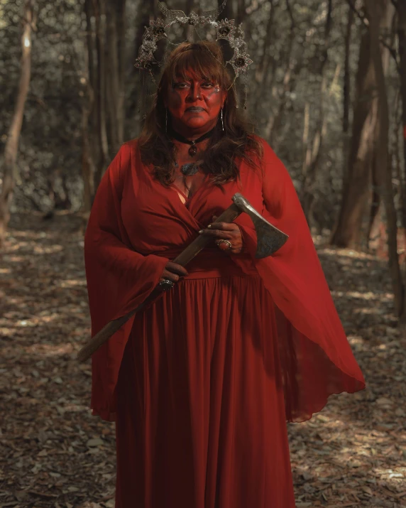 a woman in a red dress with horns and makeup on