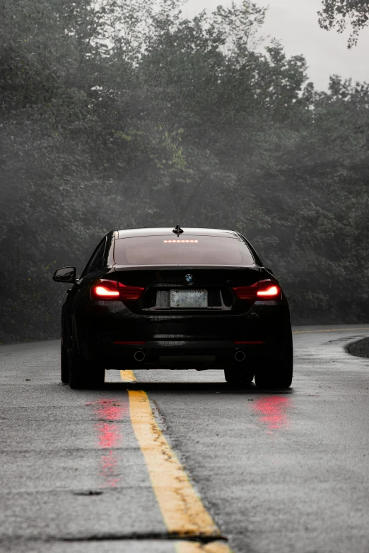 car driving on road with rain and trees in background