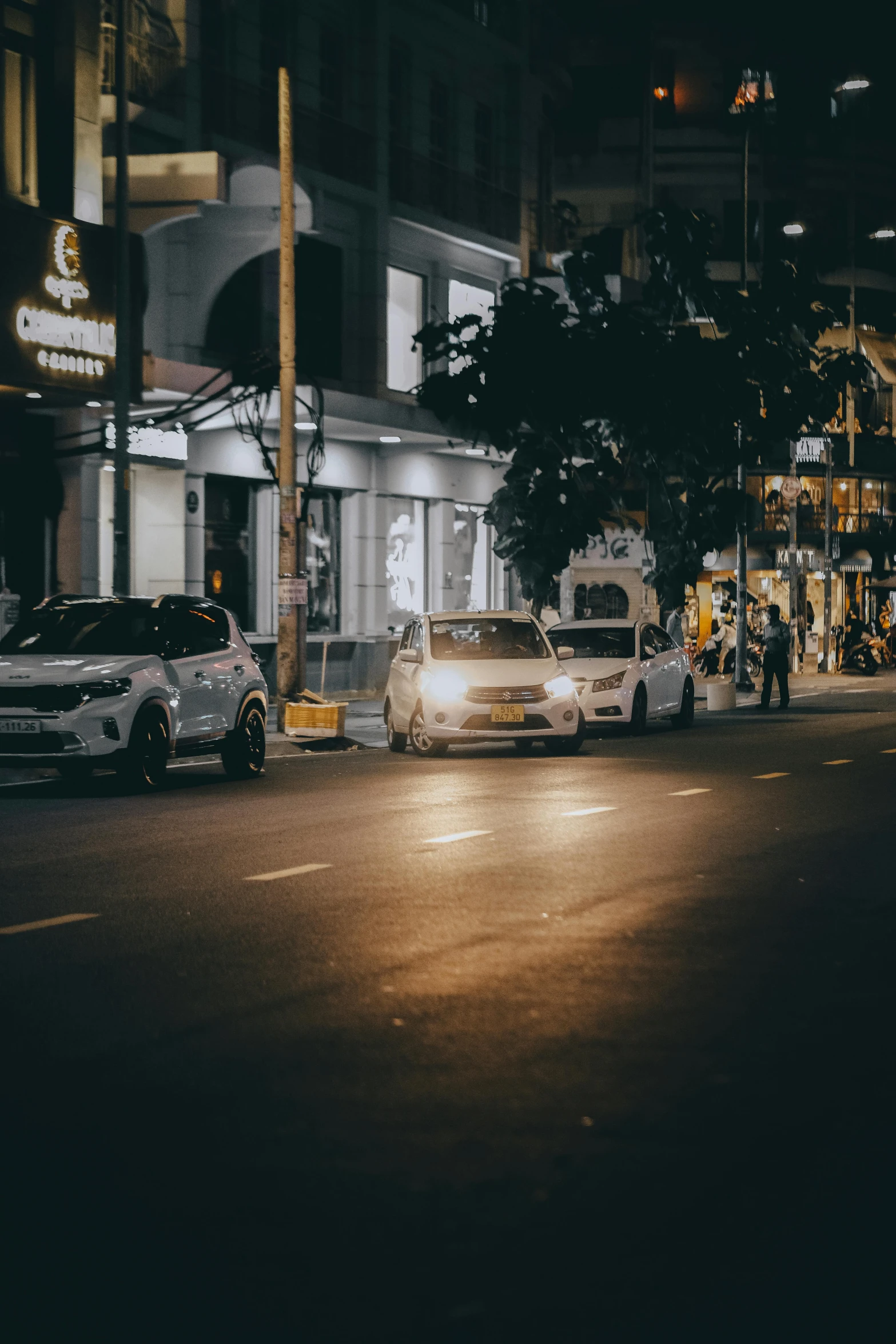 some cars driving down a street next to a building