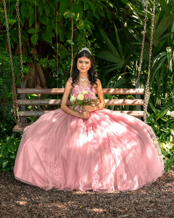 a girl in a pink dress on a porch swing