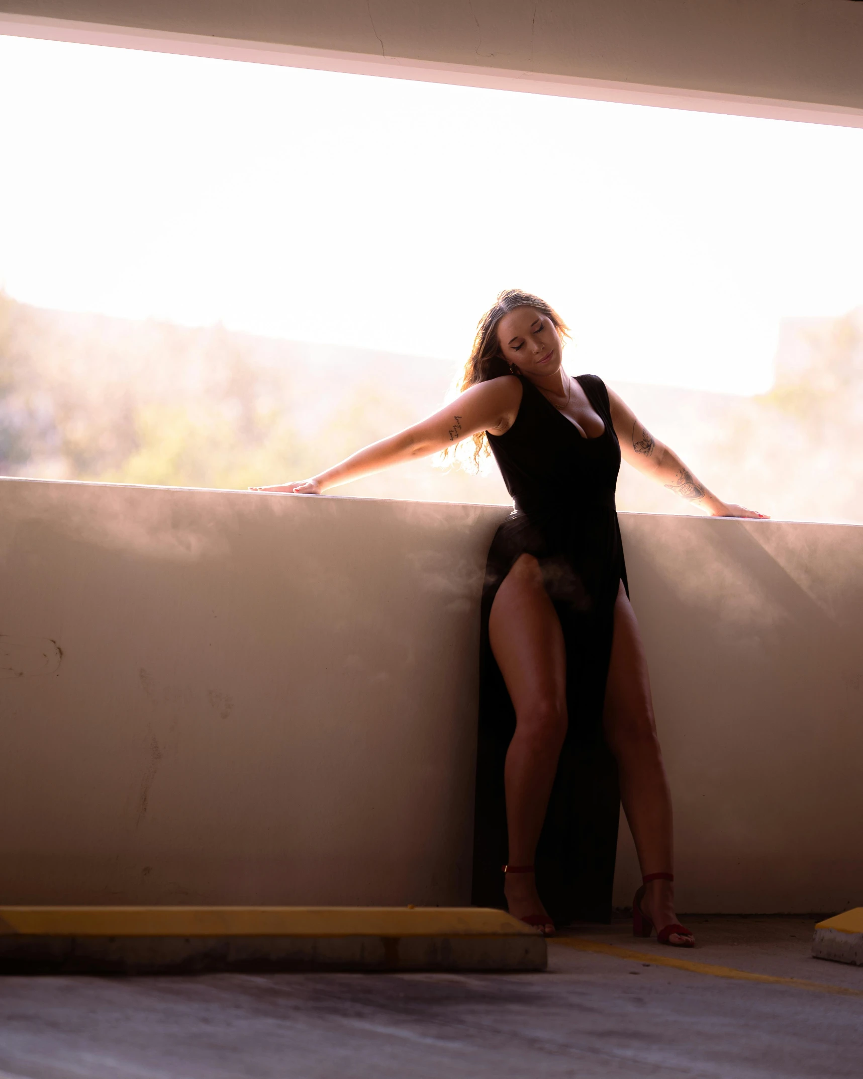 a woman wearing a  black outfit leaning against a wall