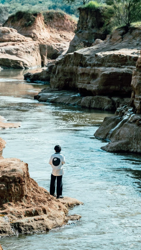 a person standing on some rocks near a body of water