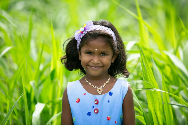 a  wearing a bright blue dress standing in tall grass