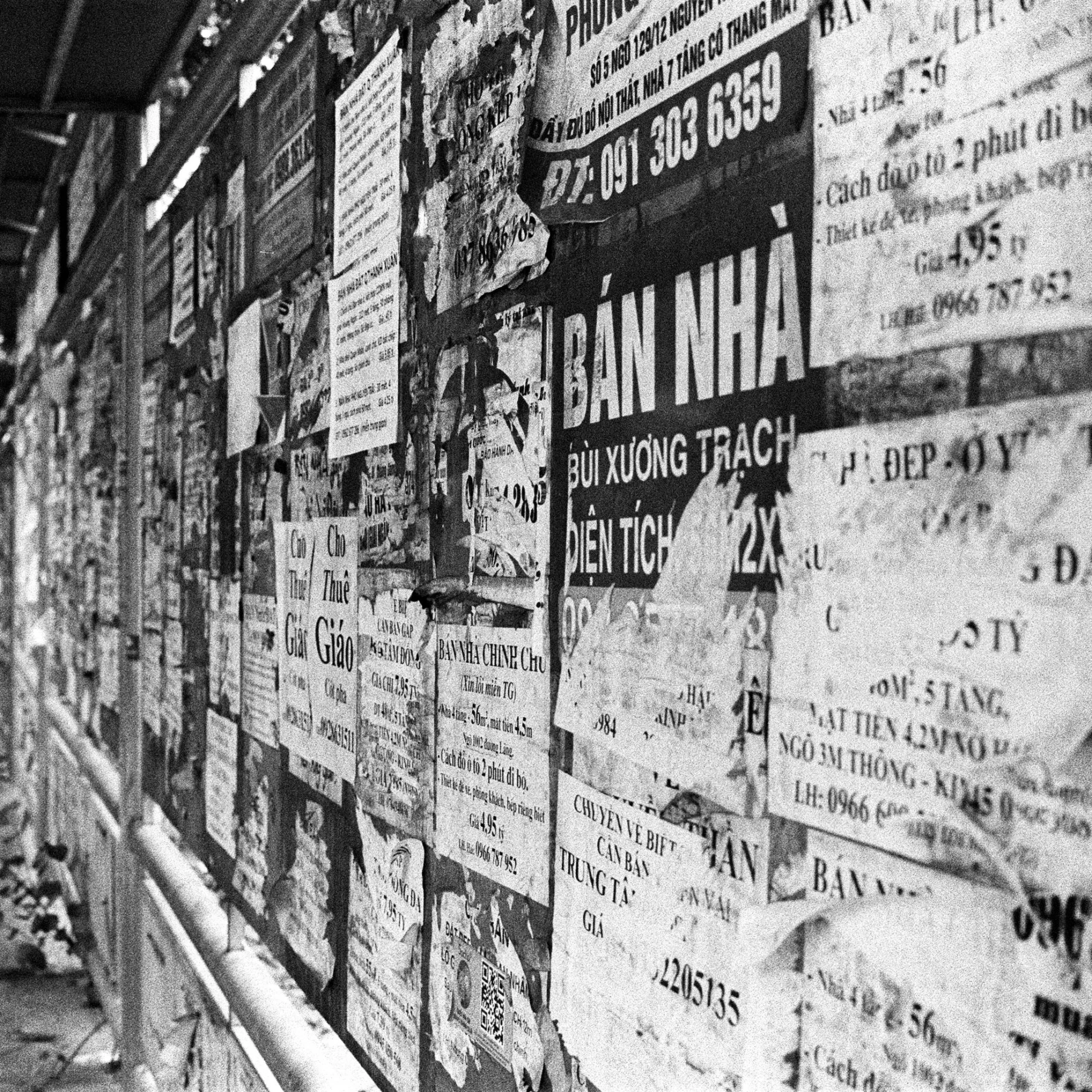 the wall covered with a lot of posters that are written