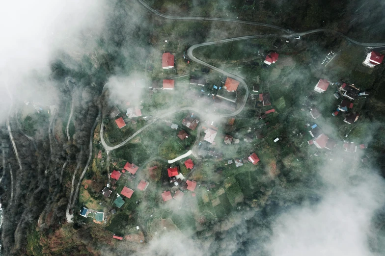 a mountain village surrounded by clouds and fog