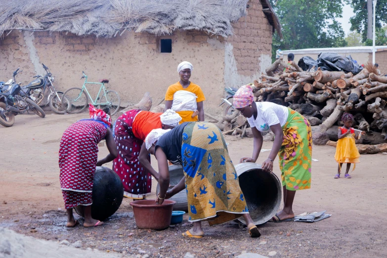 a group of women that are kneeling in the dirt