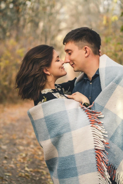 the man and woman hug while wrapped up in blankets