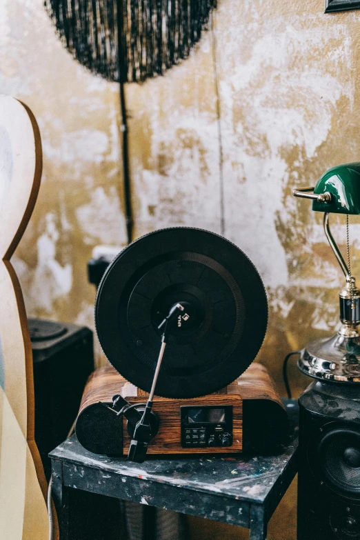 a small radio sits on a table beside two old records