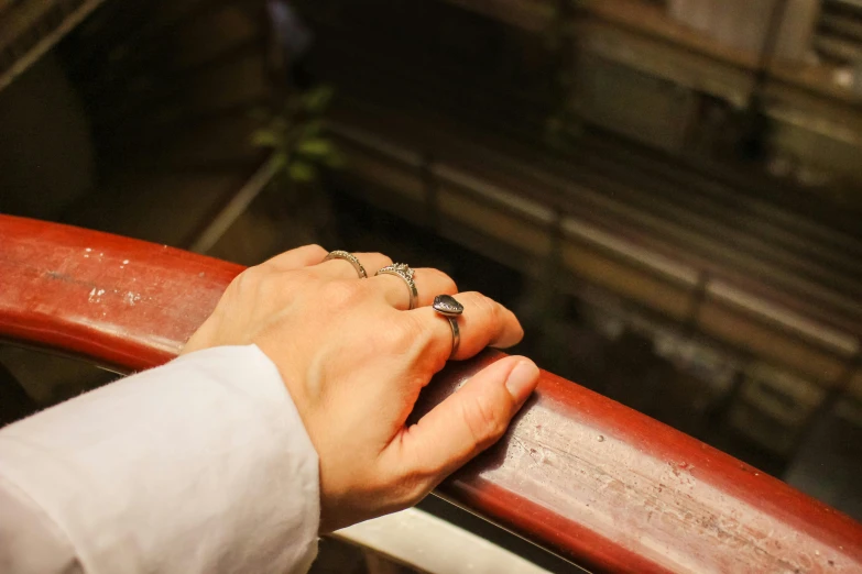 a person in a white shirt holding onto a rail