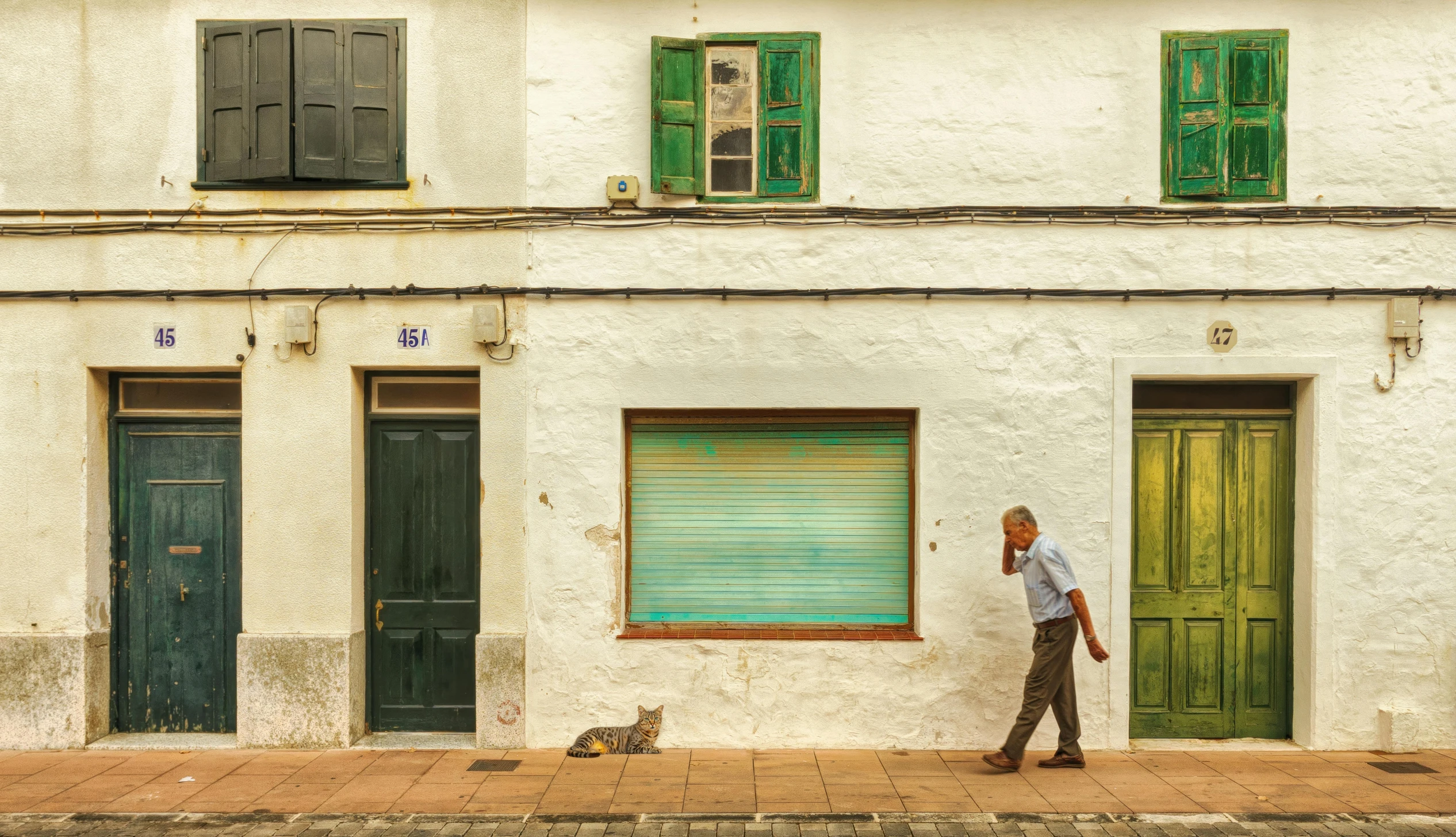 a man walking a dog on the side of a building