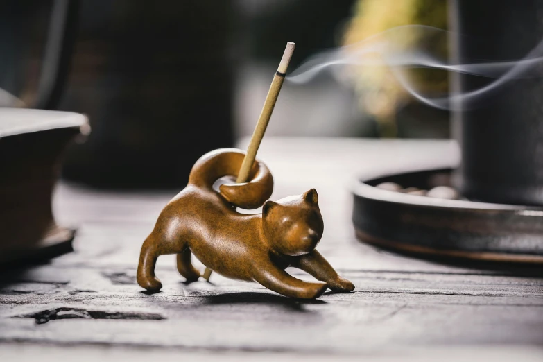 small plastic dog figure blowing incense with black background