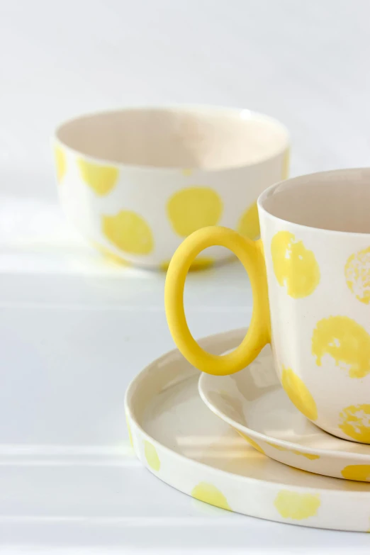 two yellow polka dot cups and saucers