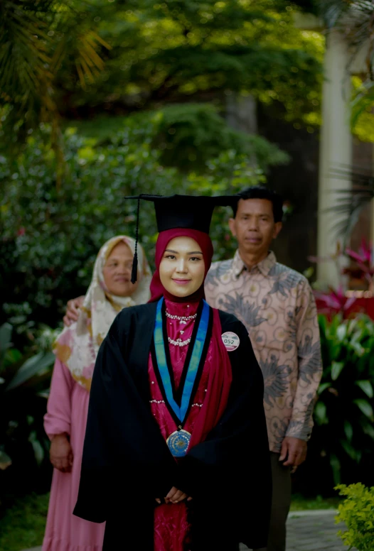 the girl is wearing a graduation gown, holding an award