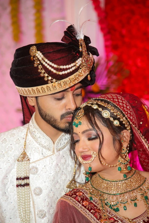 newly married couple in indian wedding outfits posing together