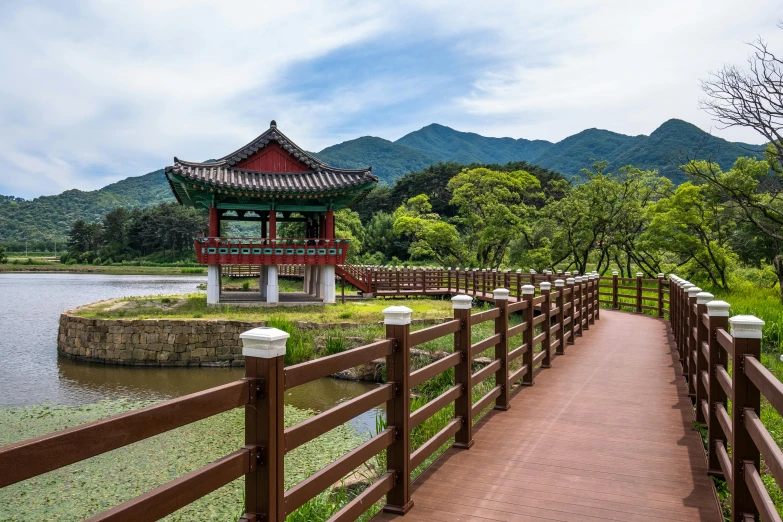 wooden path over river with bridge and pavilion