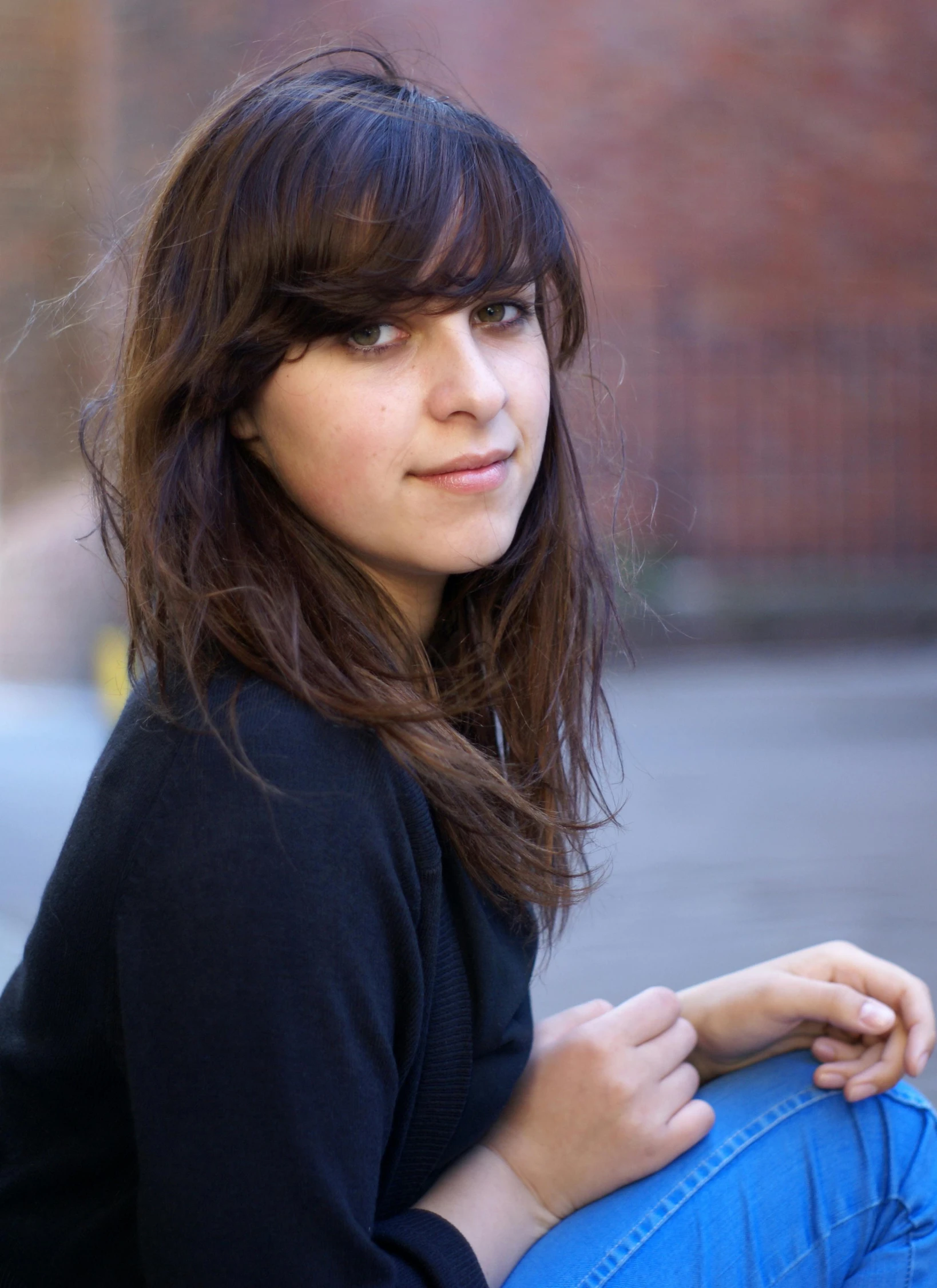 a woman sitting on the side of the street