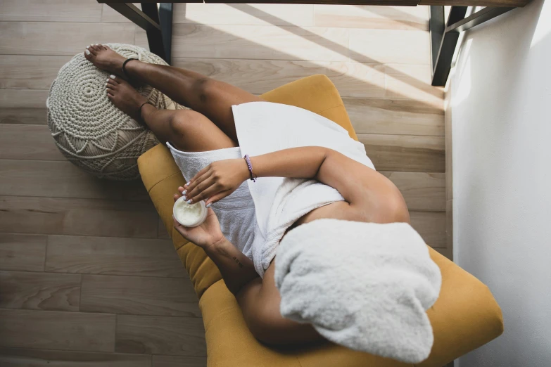 a woman in a towel is relaxing with a drink