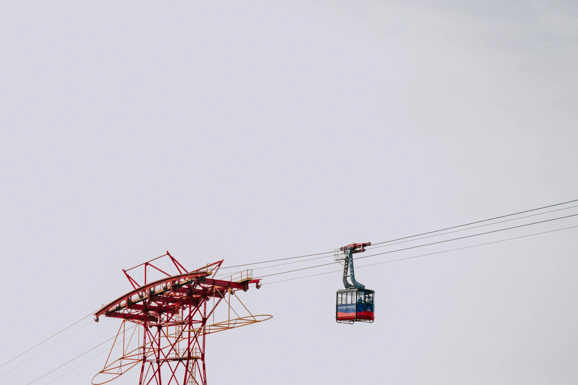 red cable cars passing by while an electric passenger train passes