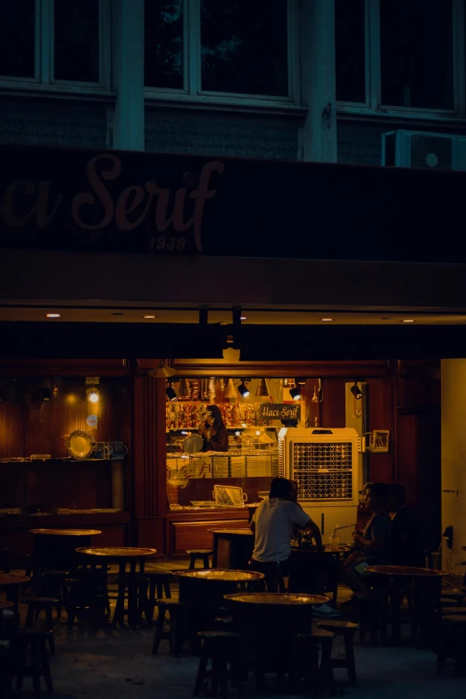 people are eating outside at night on tables