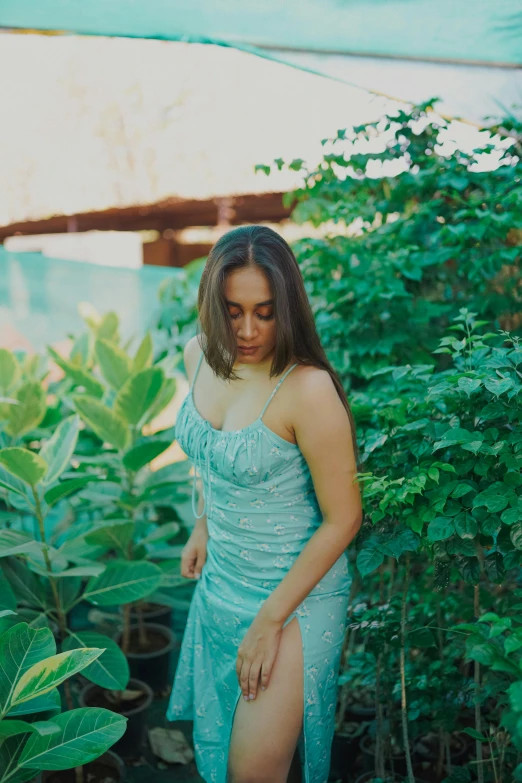 a woman in a blue dress stands in the grass