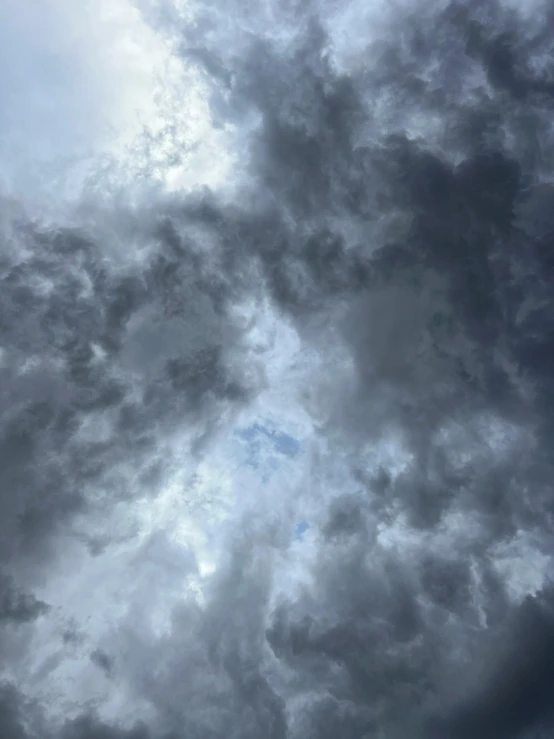 the airplane is flying through the very cloudy sky