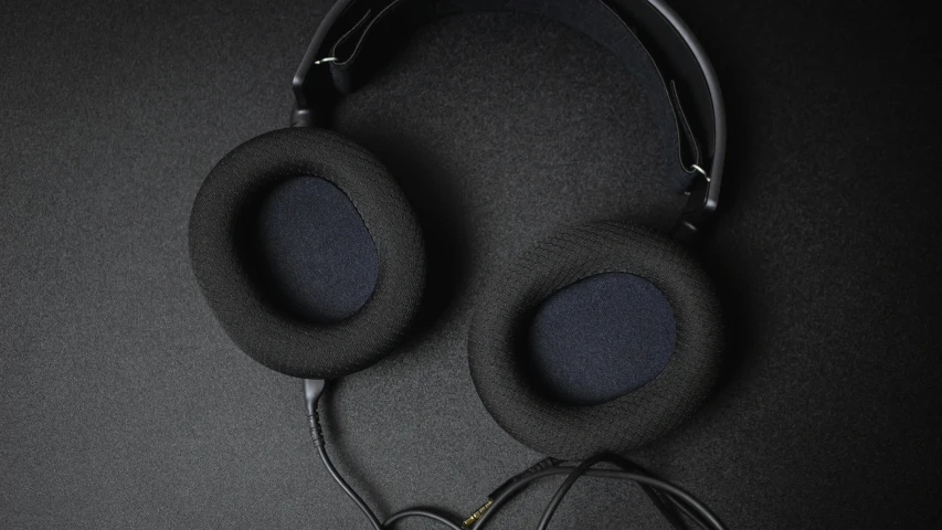 a pair of headphones and ear buds on a black background