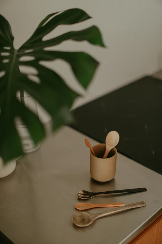 a pot of spoons and utensils on top of a table