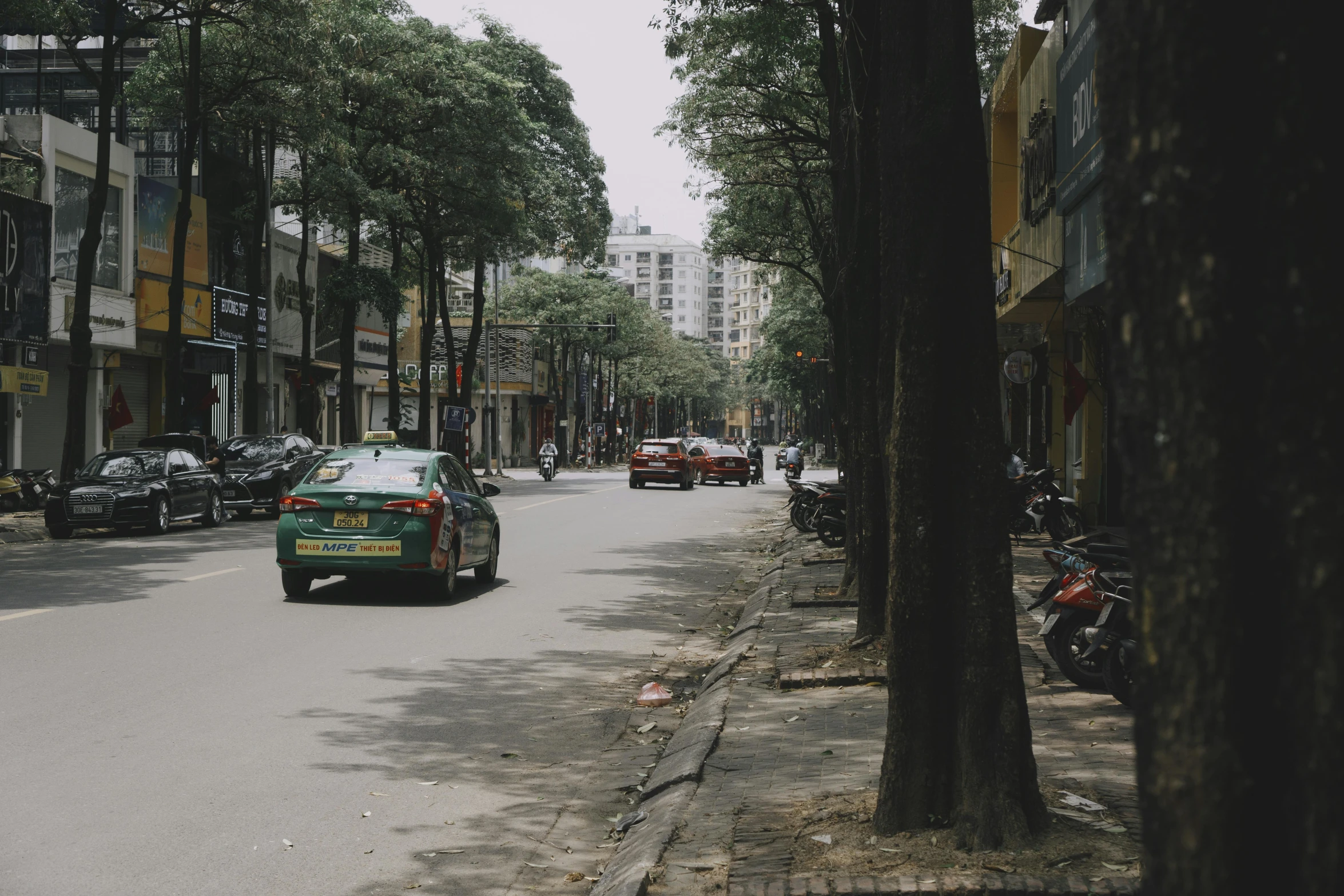 the green car is parked on the street