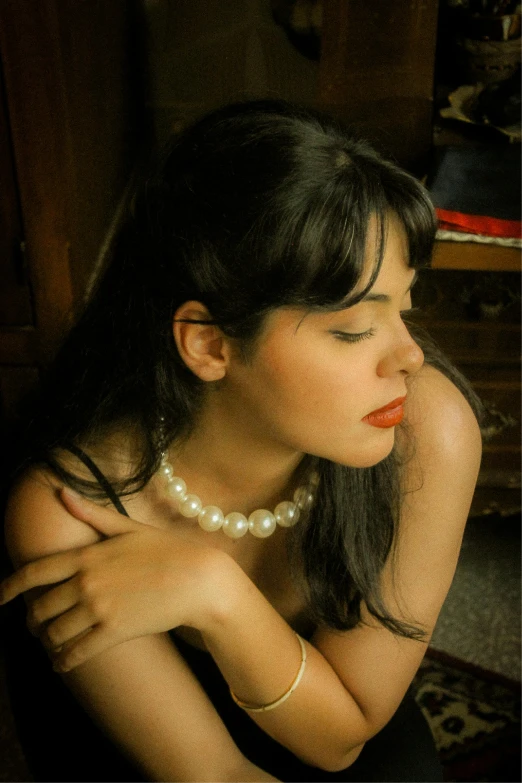 a girl posing in her bedroom with her hand near her face