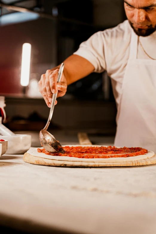 a man holding a knife and fork  into a pizza