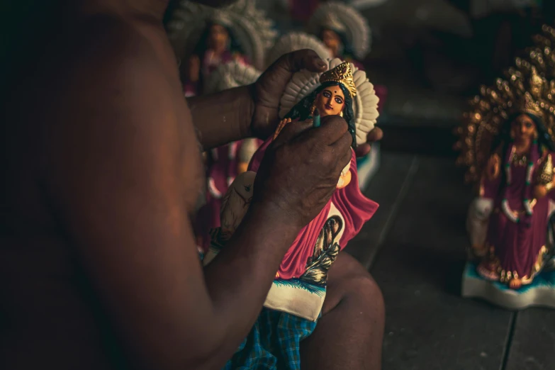 a person putting a small statue into their hand