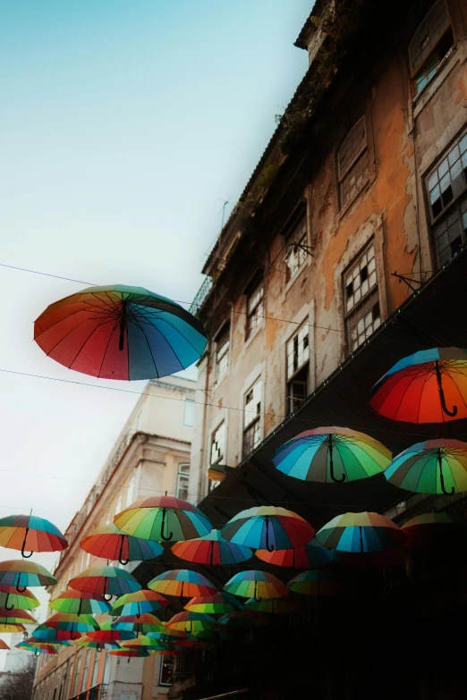 rows of colorful umbrellas hanging in an alley