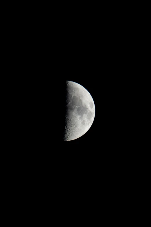 a half - moon seen from an airplane is silhouetted in the dark sky