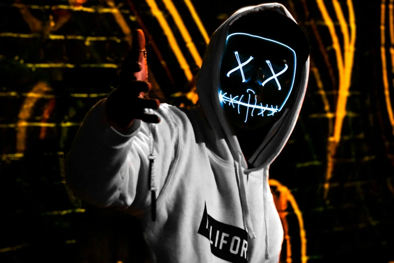 person in white sweatshirt with hoodie with neon mask pointing a finger