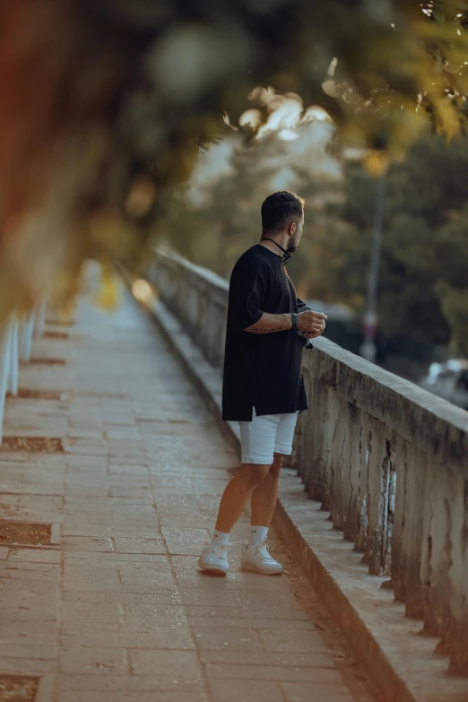 a man standing next to the edge of a walkway looking at his cell phone