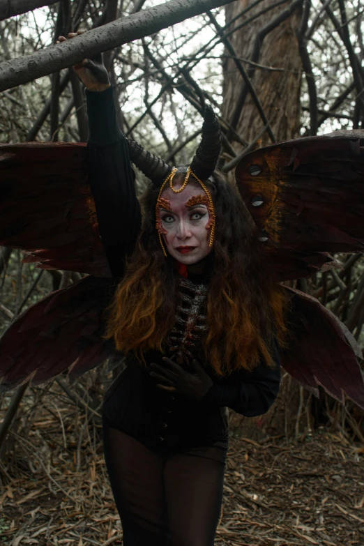 an evil looking woman with horns and wings