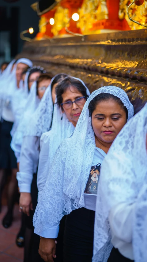 a line of women standing together outside in their veils