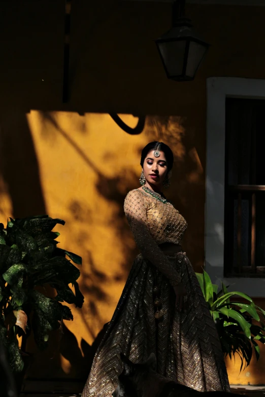 a young woman poses outside in an intricately decorated dress