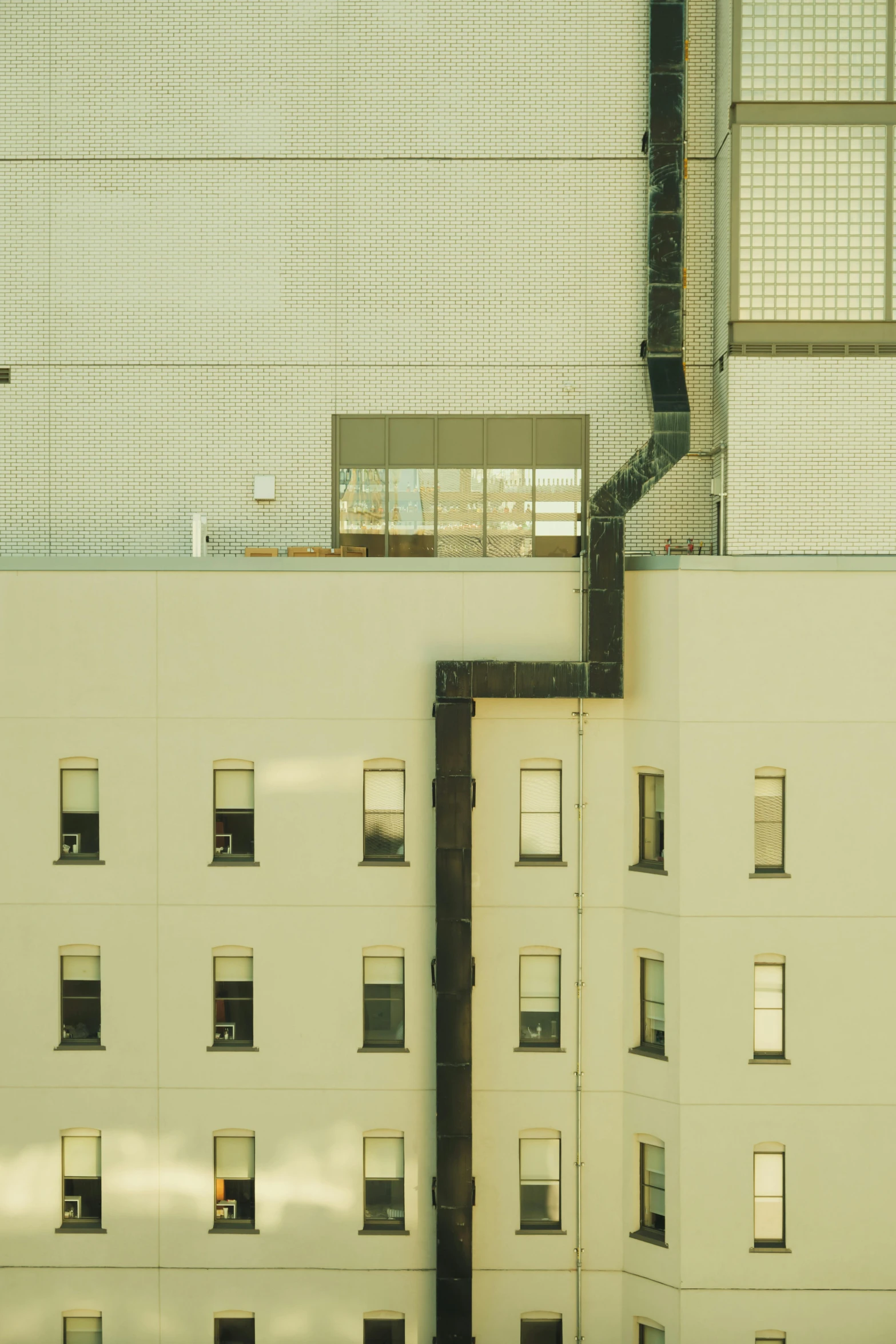 a large beige building with windows and a window grating on the side of it