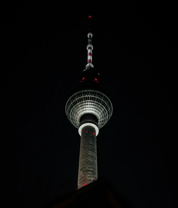 the tall tower at night has a red light on top